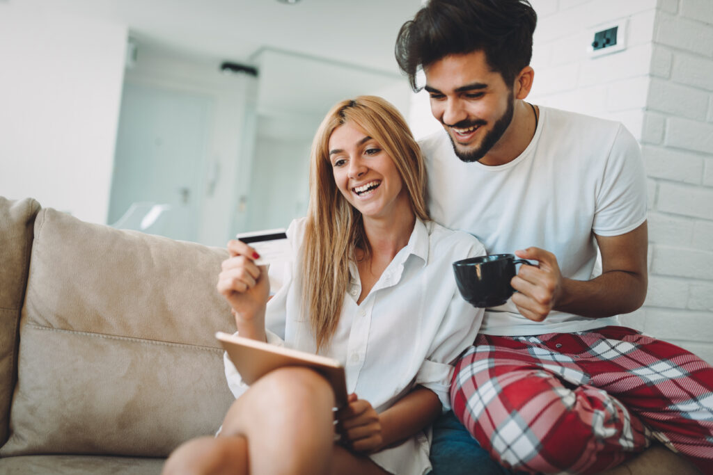 can i afford a second home - Young attractive couple spending time together at home using tablet